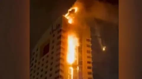 A high-rise building engulfed in flames in Kuwait City.