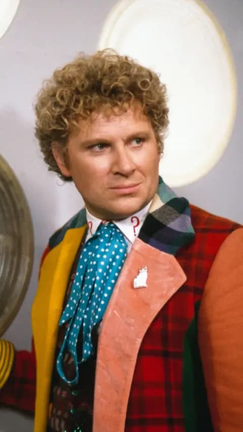 Colin Baker as Sixth Doctor in Doctor Who wearing muti-coloured coat inside the Tardis