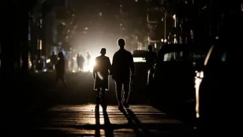 People walking in a darkened street in Havana, Cuba