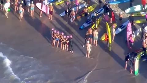 An aerial grab from video shows swimmers standing on the beach next to surfers with their boards before they paddle out, in Bondi on Friday.