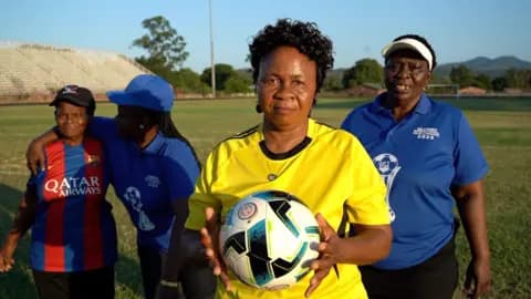 Four women stand on a football pitch in Limpopo, South Africa, wearing their jerseys.