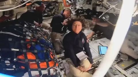 Four astronauts are seen in their spaceship.