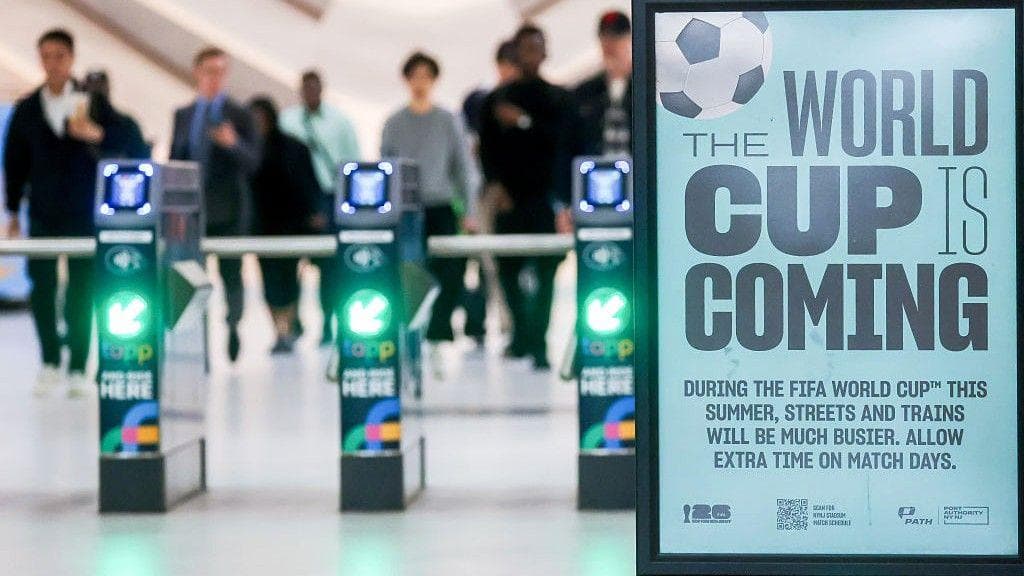 An image of turnstiles with the sign 'The World Cup is coming'