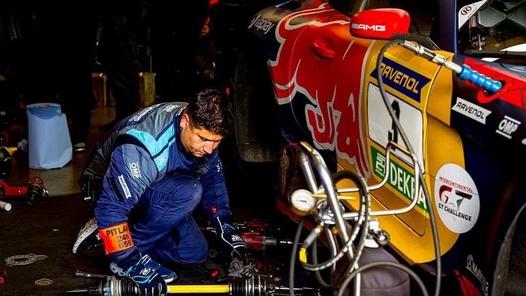 A mechanic tries to fix Max Verstappen's car at the Nurburging 24 hours