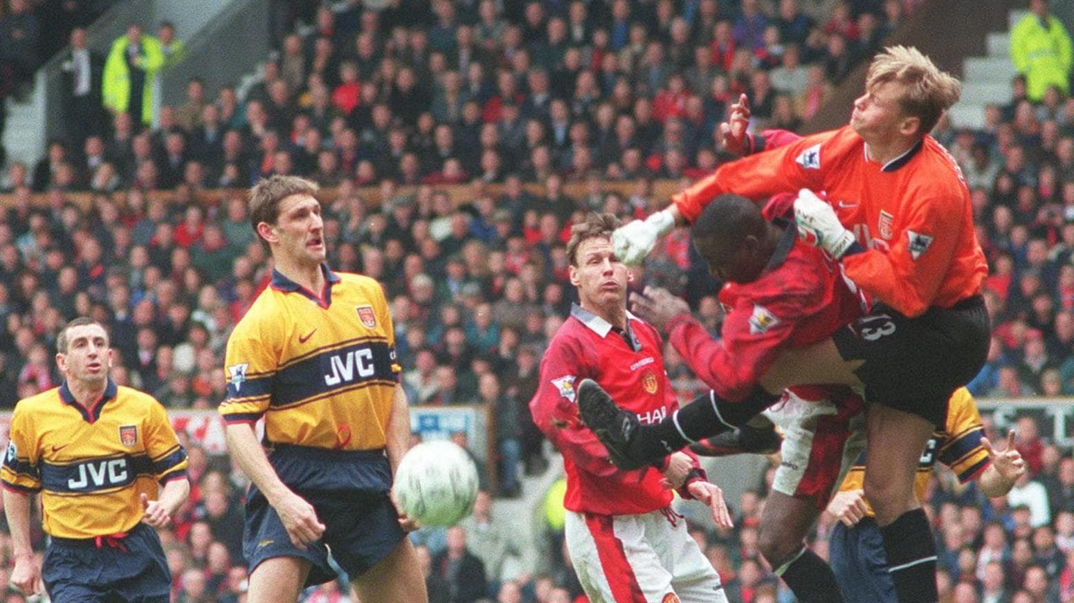 Alex Manninger punches the ball clear from Manchester United striker Andy Cole during Arsenal's crucial 1-0 win at Old Trafford in March 1998