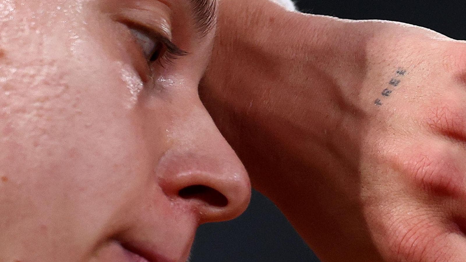 A close up of Maja Chwalinska's face with a tiny tattoo reading "free" just visible on her hand