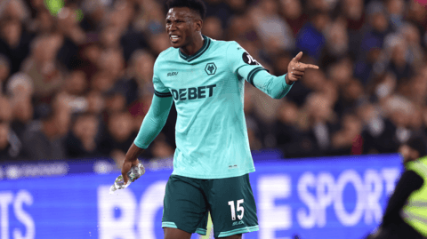 Yerson Mosquera points while holding a bottle