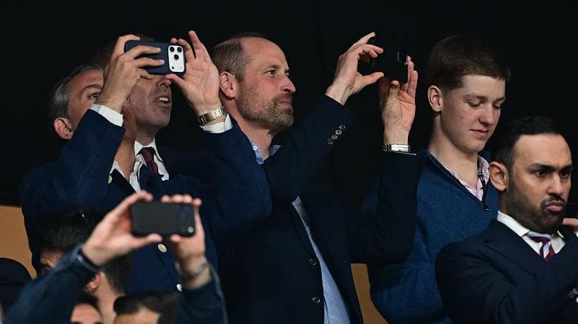 Prince William holding his phone