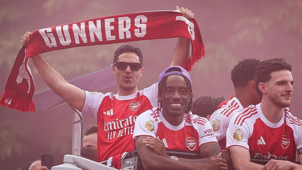 Mikel Arteta pictured wearing sunglasses and holding aloft an Arsenal scarf on the club's open-top bus parade