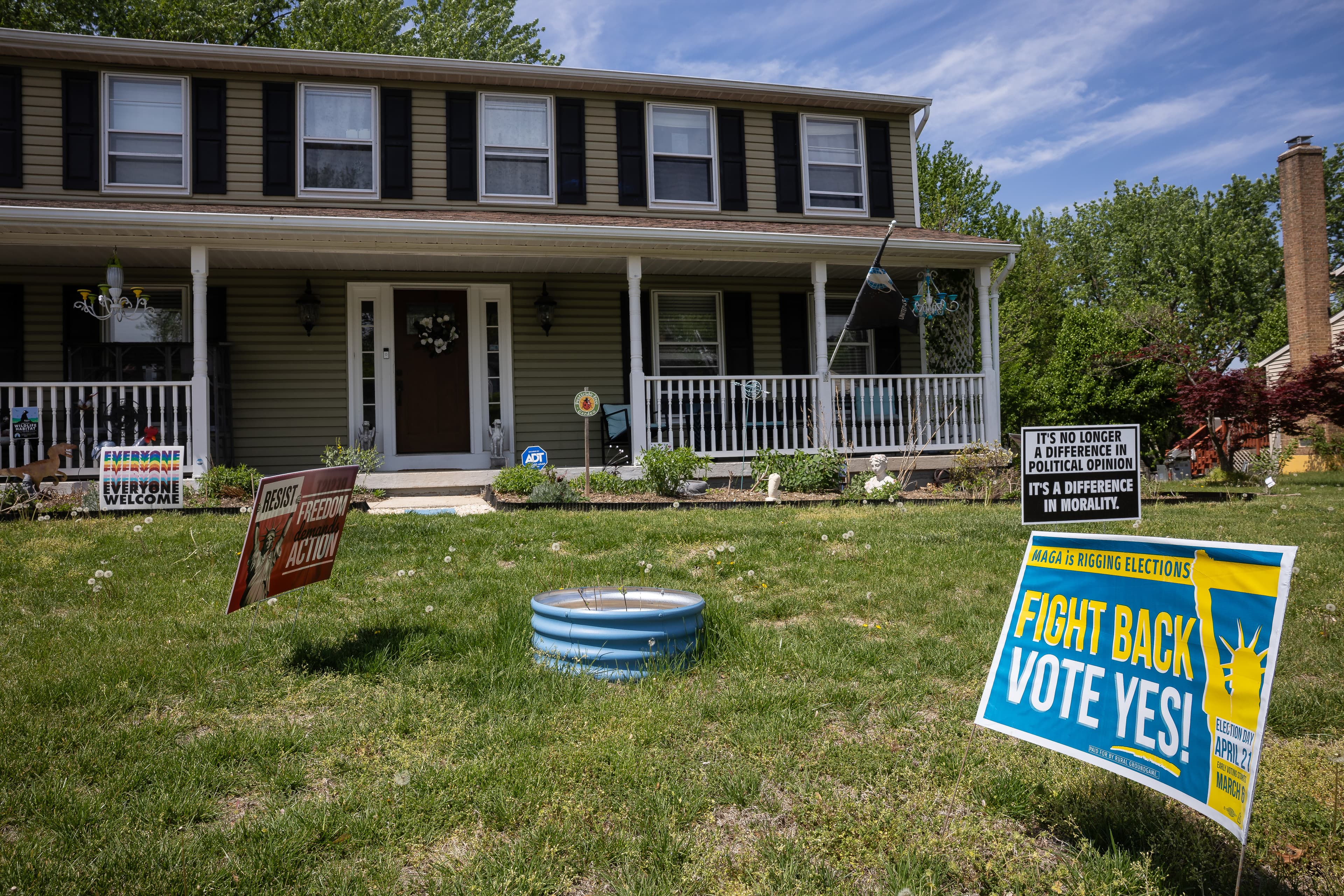 Political signs sit in the yard outside Fram's home in Reston.