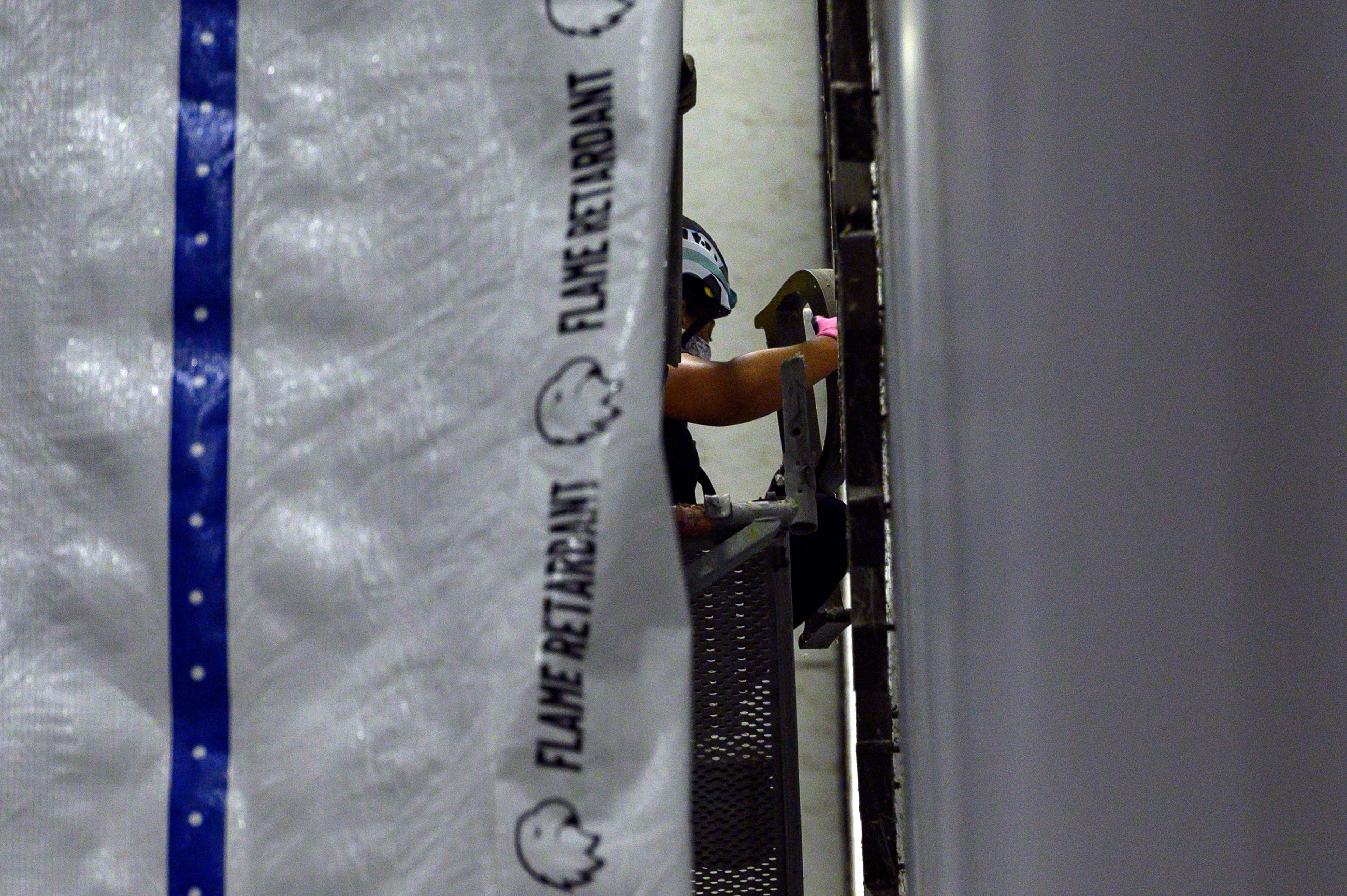 A worker removes a letter from President Donald Trump's name from the wall of the John F. Kennedy Center for the Performing Arts in Washington, June 13, 2026.
